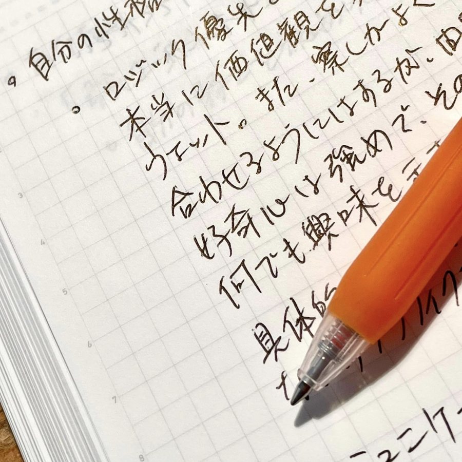 方眼ノートに手書きで書き込まれた自分史のページとシャープペンシル